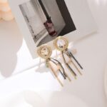 Aretes Dorados con Gemas de colores colgando